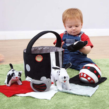 Black and white soft baby toys in basket, contrasting